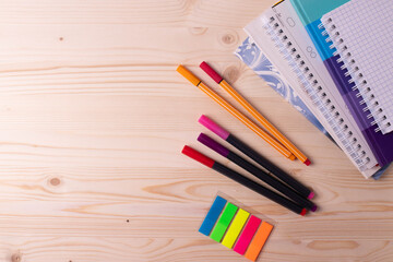 Fototapeta premium various pens and a pile of notebooks on the wooden backgrounds