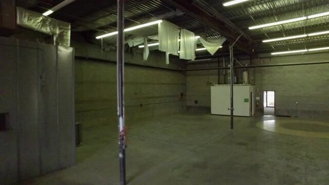 Panning video of empty warehouse interior. Aerial video of empty warehouse.