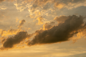 Naklejka na ściany i meble cumulus clouds during golden hour.