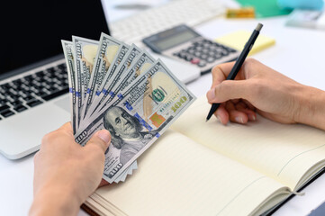 Business people hold pen and money calculate
