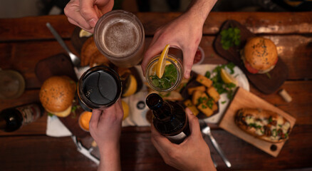 Dinner table with baked potatoes,burgers, sauces, beer and wine
