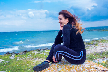 happy woman sitting naer lake