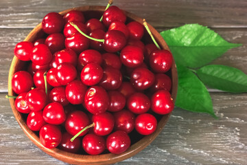 ripe cherry berries in a wooden bowl top view. background with cherry berries in a bowl.