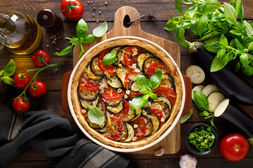 Tart with vegetables. Homemade savory tart with eggplant, zucchini, tomatoes, garlic, mozzarella cheese and fresh basil. Mediterranean  cuisine. View from above