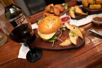 Dinner table with baked potatoes,burgers, sauces, beer and wine