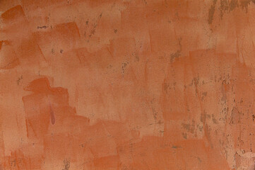 Orange painted stained weathered peeling wall.