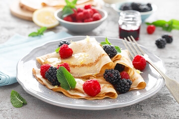 Thin crepes with fresh berries and lemon zest. Pancakes with raspberry and blackberry.