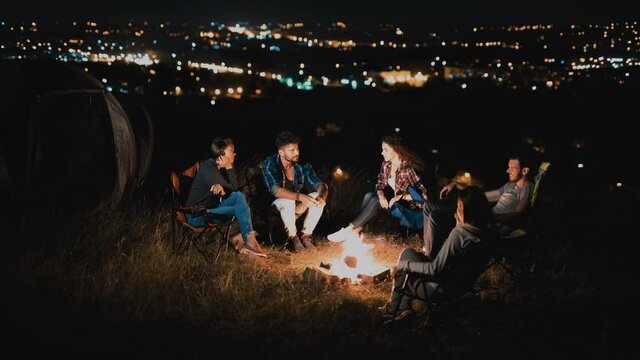 The young people sitting near the night campfire