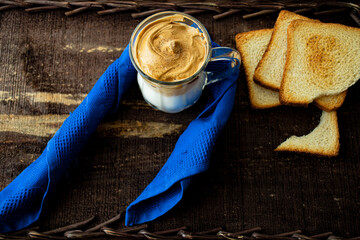 
Dalgona coffee in glass cup with blue napkin and toast - obrazy, fototapety, plakaty