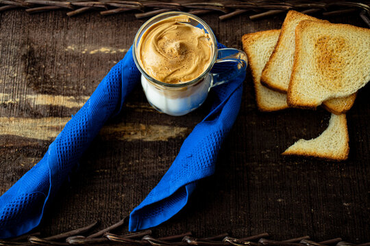 
Dalgona coffee in glass cup with blue napkin and toast