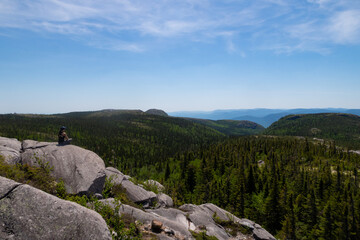 Young woman sitting in the Grands-Jardins national park, Canada 