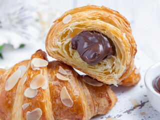 Yummy freshly croissant, sliced almonds, with chocolate filling cut, close up - 363969794