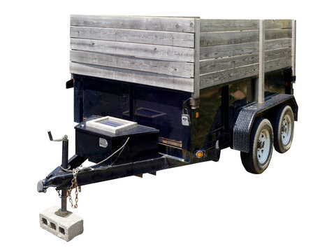 Utility trailer with wooden extension parked residential neighborhood street.