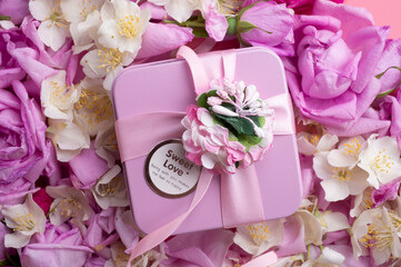 box with gift  around roses  and  jasmine background. romantic and beauty concept