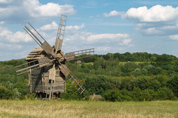 Fototapeta premium Mill in the middle of a field against a beautiful sky