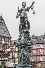 Fototapeta premium Statue of Lady Justice in front of the Romer at Romerberg (Romerplatz) in Frankfurt am Main, Germany.