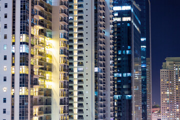 Fototapeta na wymiar Apartment windows at night in big city highrises.