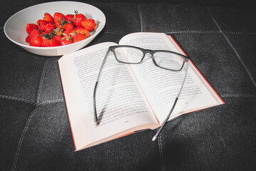kompozycja z okularów ksiązki i truskawek 