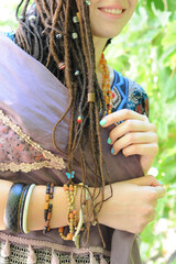 Beautiful young woman with dreadlocks hairstyle decorated assorted beads
