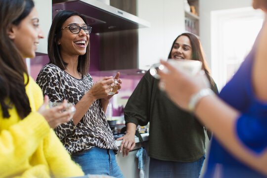 Happy women drinking tea in kitchen