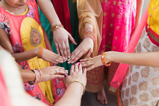 Indian women in saris joining hands in circle