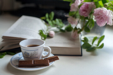 cup of coffee and book on wooden table