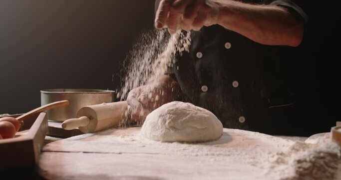 Experienced elderly caucasian chef is putting flour and kneading dough, using traditional recipes, pensioneer enjoying his hobby after retirement, isolated on black background 4k footage