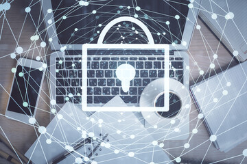 Double exposure of lock hologram drawing over study table background with computer. Concept of data security. Top view.