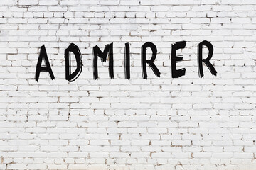 Inscription admirer painted on white brick wall