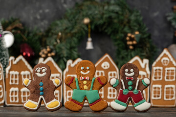Decorated gingerbread houses christmas cookies with christmas wreath on dark table