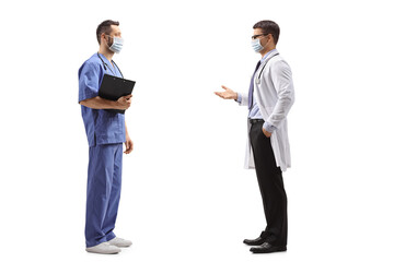 Medical worker in a blue uniform and a doctor with protective face masks talking