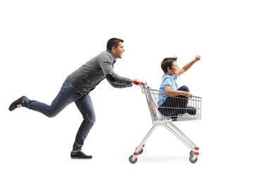 Man running and pushing a boy inside a shopping cart - obrazy, fototapety, plakaty