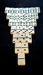 inverted triangle built of domino pieces on a black background