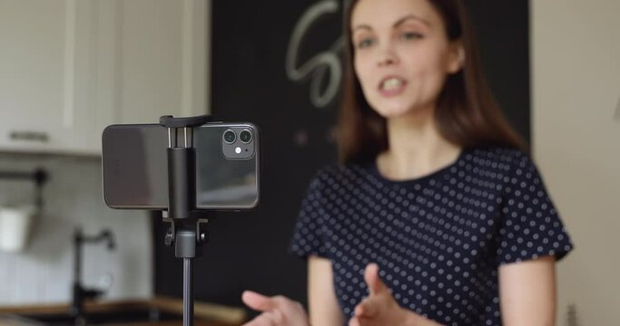 Woman puts phone on tripod record video tell information, share personal experience ideas, talk about herself, life story. Vlogging, modern technology, work use internet, job interview filming concept