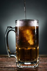 beer mug with foam on a wooden board