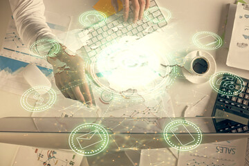 Double exposure of man's hands typing over computer keyboard and social network theme hologram drawing. Top view. People connection web concept.