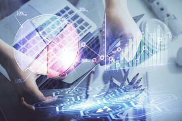 Double exposure of businesswoman hands typing on computer and financial graph hologram drawing. Stock market analysis concept.