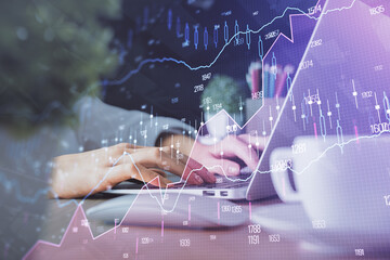 Double exposure of woman hands typing on computer and forex chart hologram drawing. Stock market...
