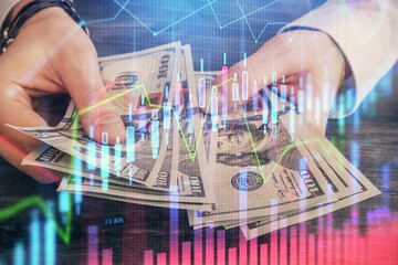 Multi exposure of financial graph drawing hologram and USA dollars bills and man hands. Analysis concept.