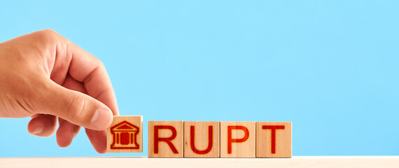 bankrupt concept. man stacks wooden blocks with a bank icon and letters in the word bankruptcy