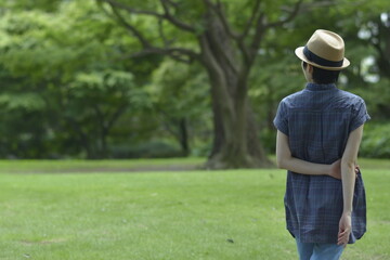 Asian young women.  like spending time in the middle of nature.   wear a hat at a rakish angle.  blurred background with copy space.