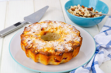 Golden homemade muffin with nuts on white wooden table, napkin.