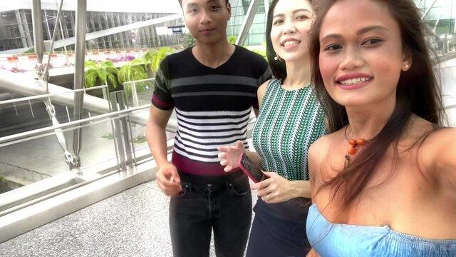 Smiling asian young people visting city. Three happy friends