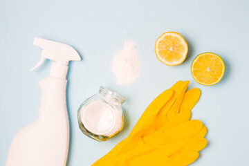 rubber gloves, a white bottle of spray without a label, half lemon and lime, spilled soda and a...