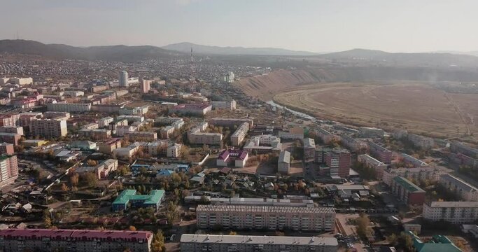 Aerial view of the city of Ulan-Ude. Russia Siberia. Rivers, apartment buildings, highway, busy traffic, hills, smoke, foggy weather. 4K