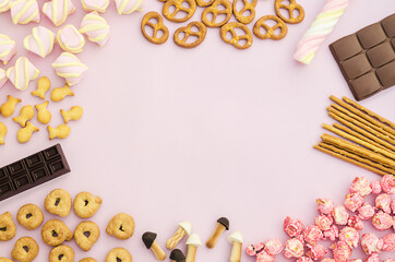top view, flat lay, frame on sweets, candies, marshmallows, chocolate, popcorn, cookies on pink background, copy space, text. The concept of female, children's holiday, diet, junk food.