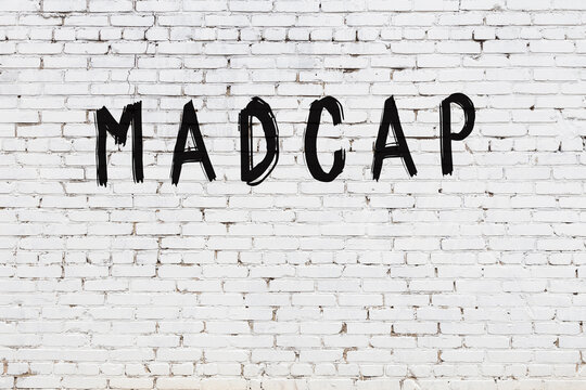 Inscription madcap painted on white brick wall