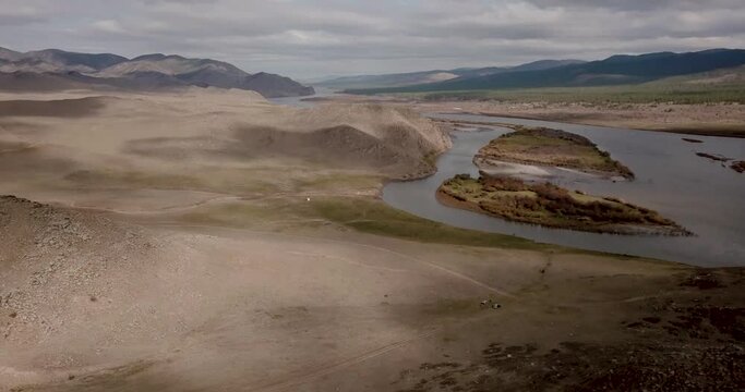 Dramatic fall dark desert steppe on a highland mountain plateau with ranges of hills on a horizon storm skyline. Aerial view of river and hills in Siberia near the city of Ulan-Ude, Russia. 4K