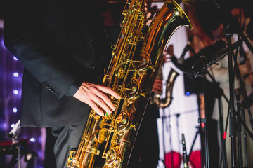 Concert view of a saxophonist, saxophone player with vocalist and musical during jazz orchestra...