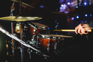 View of drum set kit on a stage during jazz rock show performance, with band performing in the...